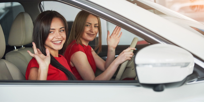 young girl twins sitting on the front passenger seats and smiling.jpg